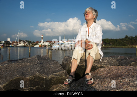 Frau sitzt auf dem pier Stockfoto