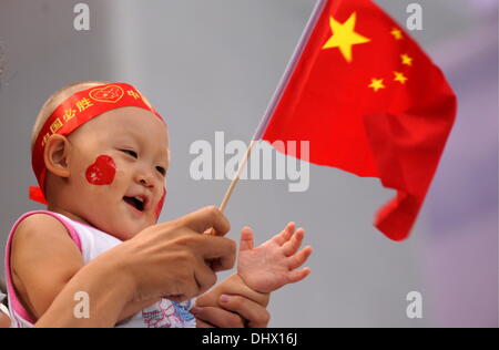 (Datei) - eine Archiv Bild, datiert 10. August 2008, zeigen Sie ein Kind winken die chinesische Flagge während der Olympischen Spiele in Peking, China. China ist zum entspannen ihre ein-Kind-Politik erklärt der chinesischen kommunistischen Partei in Peking am 15. November 2013. Foto: Bernd Thissen/dpa Stockfoto