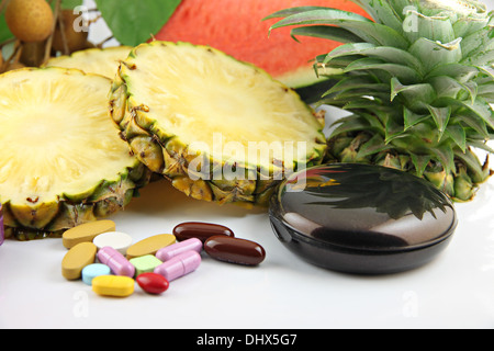 Obst und Medikamente platziert in der Nähe der Kosmetik auf weißem Hintergrund. Stockfoto