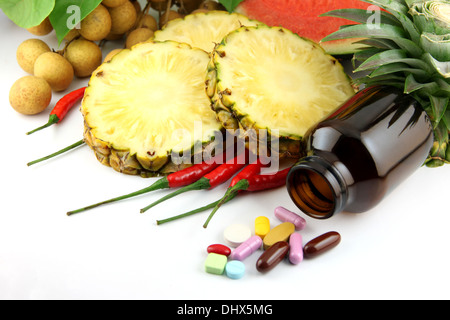 Obst und Medikamente platziert in der Nähe von Kosmetik und Gemüse, auf weißem Hintergrund. Stockfoto