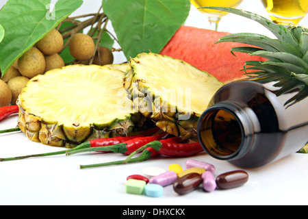 Obst und Medikamente platziert in der Nähe der Kosmetik auf weißem Hintergrund. Stockfoto