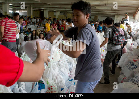 International Convention Centre, Cebu City 16.11.2013. Eine Cebu City Initiative eine Reihe von Regierungsbehörden in der Nachmahd der Taifun Haiyan/Yolanda. Eine 24-Stunden-Hilfsaktion Hilfe beinhaltet die empfangende und neu verpacken von Lebensmitteln, die für die am schwersten betroffenen Gebieten bestimmt sind. Freiwillige Helfer sind vor allem Studenten. Relief-Packs enthalten 6 Kilo Reis, 5 Dosen Sardinen, 5 Dosen corned Beef/Rind Laib. Stockfoto