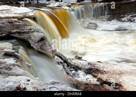 Fließenden Wasserfall namens Keila Juga in Estland mit großen Stück der schmelzende Schnee und Eis im Winter. Stockfoto