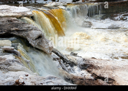 Fließenden Wasserfall namens Keila Juga in Estland mit großen Stück der schmelzende Schnee und Eis im Winter. Stockfoto