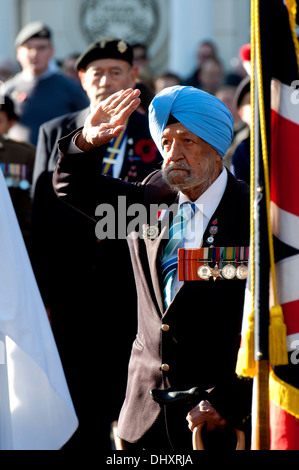 Ein Sikh veteran salutiert nach der Verlegung eines Mohn Kranz an den Leamington Spa Erinnerung sonntäglichen Gottesdienst. Stockfoto