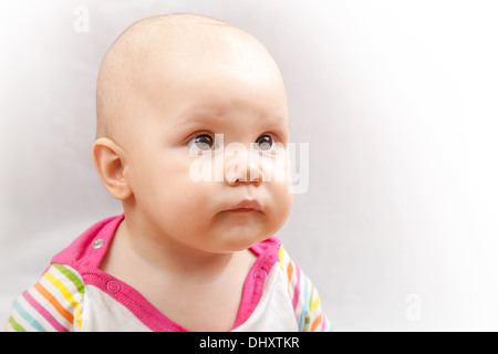 Little, Brown eyed kaukasischen Baby Studioportrait auf grauem Hintergrund Stockfoto