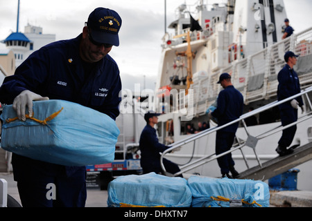 Petty Officer 1st Class Francisco Acevedo, Crewmitglied an Bord der Coast Guard Cutter kräftig, stapelt Ballen von Kokain während einer Droge Offload in Port Everglades, Florida, 15. November 2013. Das Gesamtgewicht des Kokains abgeladen wurde 1.212 Kilogramm. Coast Guard pho Stockfoto