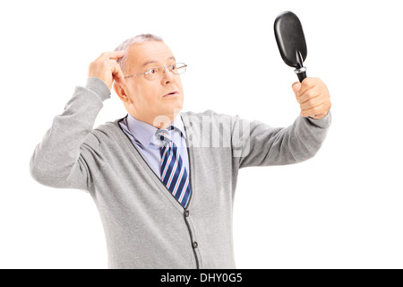 Applying Gentleman für dünnes Haar im Spiegel überprüfen Stockfoto