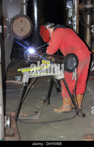 Ein Schweißer trägt seine volle persönliche Schutzausrüstung PSA Stockfoto