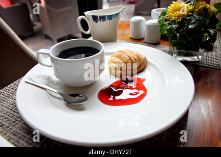 Kaffee, Brot und Marmelade auf einem weißen Teller. Stockfoto