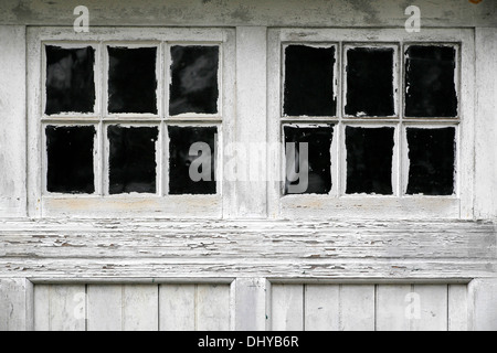 Wetter geschlagen alte Garagentore, schlampig gemalt, um die Fensterscheiben. Stockfoto