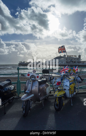 Lambetta Motorroller Parken direkt am Meer, mit dem Palace Pier im Hintergrund.   Brighton, East Sussex, England UK Stockfoto