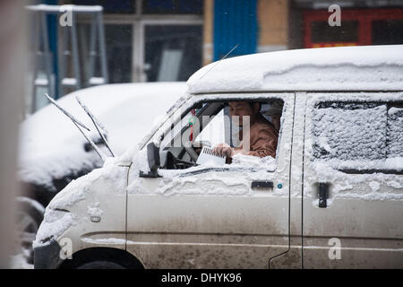 Jilin. 16. November 2013. Eine Mann räumt Schnee aus seinem Auto nach ein Schneesturm die Stadt Jilin im nördlichen China.A Blizzard hit hit der nördlichen Stadt Jilin in China bringt Verkehrschaos und Schnee und Eis auf den Straßen machen das Autofahren gefährlich, aber es gibt auch die Menschen draußen im Schnee fühlen ihr Glück bringen. Bildnachweis: Zhijun Sonne/Alamy Live News Stockfoto