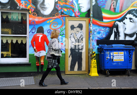 Eine Leinwandkopie der Banksy-Graffiti-Kunst der beiden küssenden Polizisten (küssende Coppers) an der Wand im Prince Albert Pub in Brighton, Großbritannien, plus George Best - Stockfoto