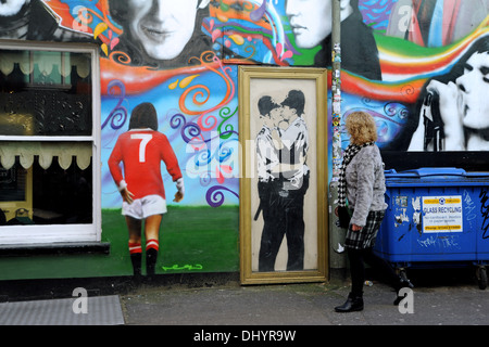 Eine Leinwandkopie der Banksy-Graffiti-Kunst der beiden küssenden Polizisten (küssende Coppers) an der Wand im Prince Albert Pub in Brighton, Großbritannien, plus George Best - Stockfoto