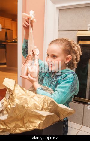 Junges Mädchen öffnet ein präsent mit neuen Ballett Spitzenschuhe Stockfoto