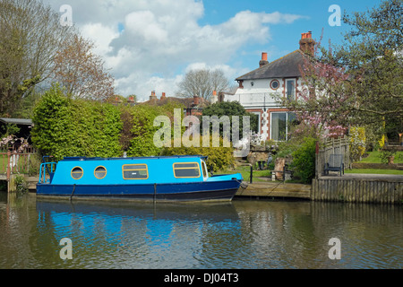 Ein Haus mit festgemachten schmale Boot auf dem Fluss Wey Navigation zwischen Guildford und Godalming, Surrey, England. Stockfoto