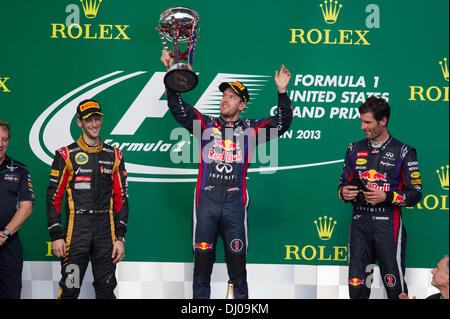 Austin, Texas, USA. 17. November 2013. 17 NOV 13 Austin, TX USA: Sieger Sebastian Vettel Deutschlands hisst die F1-Trophäe wie Romain Grosjean (l) und Mark Webber (r) Uhr während der Formel 1 United States Grand Prix auf dem Circuit of the Americas in der Nähe von Austin, TX verfolgen. © Bob Dämmrich/Alamy Live-Nachrichten Stockfoto