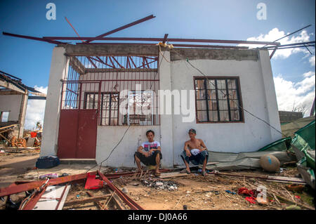 Bewohner sitzen vor ihrem zerstörten Haus in der Nachmahd des Super Taifun Haiyan 15. November 2013 in Guiuan, Philippinen. Stockfoto