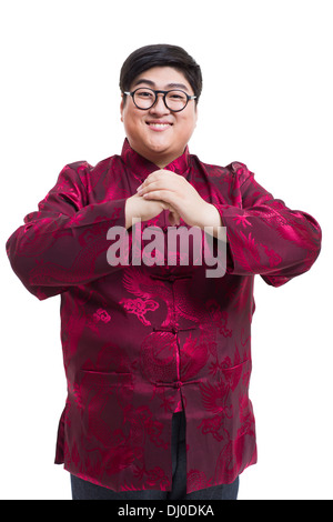 Junger Mann in Tang Anzug Gruß für Chinese New Year Stockfoto
