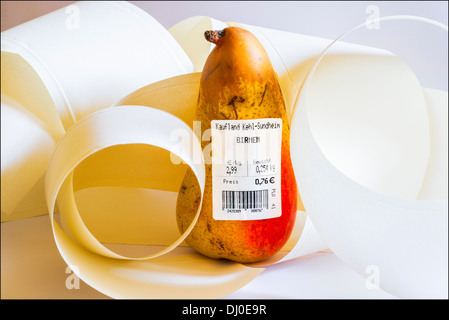 Eine Birne mit deutschen Barcode-Label zeigt Gewicht und Preis in Euro unter Papier Rollen Stockfoto