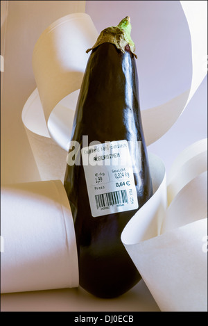 Eine Aubergine mit deutschen Barcode-Label zeigt Gewicht und Preis in Euro unter Papier Rollen Stockfoto