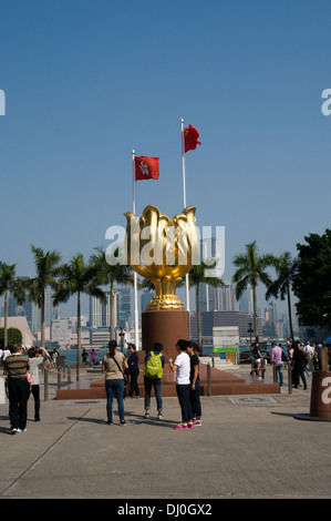 Touristen fotografieren die ewig blühen Bauhinai Scuplture, die vor dem Hong Kong Convention Center steht Stockfoto