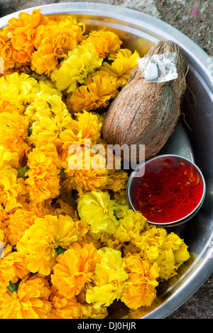 Metall-Behälter mit indischen Ringelblume Blüten, Kokosnuss und Kum Kum-Pulver für ein hindu Puja in Indien Stockfoto