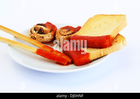 Zwieback mit Sesam, Brot-Sticks und roter Soße auf grauem Hintergrund isoliert. Stockfoto