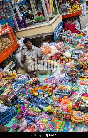 Indischer Mann billig Plastikspielzeug auf einem indischen Markt zu verkaufen. Andhra Pradesh, Indien Stockfoto