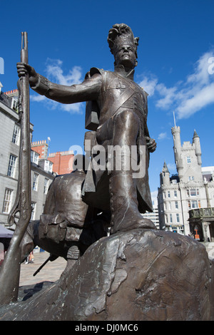 Stadtzentrum von Aberdeen, Schottland. Die Mark Richards Skulptur die Gordon Highlanders mit Mercat Cross im Hintergrund. Stockfoto