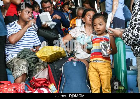 Manila, Philippinen. 18. November 2013. Evakuierten aus Tacloban erhalten Essen und Wasser den Moment, den ihrer Villamor Airbase in Pasay City, südlich von Manila Ankunft. --Tausende von vertriebenen Personen aus Tacloban und Ormoc City waren für Tierheim nach Villamor Airbase in Pasay City, südlich von Manila geflogen. Freiwillige helfen, füttern und beraten die evakuierten, die emotionales Trauma erlitten nach Überlebenden einer der größten Stürme, Land, Haiyan.Photo zu schlagen: J Gerard Seguia/NurPhoto Credit: J Gerard Seguia/NurPhoto/ZUMAPRESS.com/Alamy Live News Stockfoto