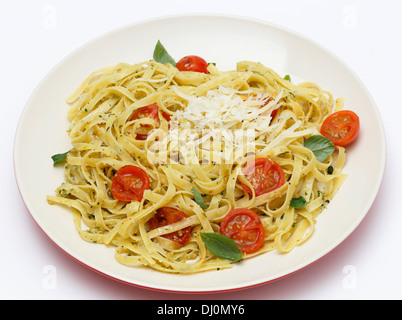 Tagliatelle Bandnudeln warf mit einer grünen, Basilikum-Pesto und Cherry-Tomaten, garniert mit Basilikum, garniert mit parmesan Stockfoto