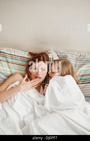 Mutter und Tochter Fragen liegen im Bett, Stockfoto