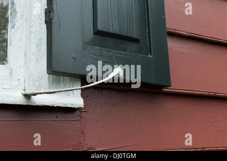 Alte schwarze Haus Rollläden vor weißem trim und roten Holz Schindeln Abstellgleis Stockfoto