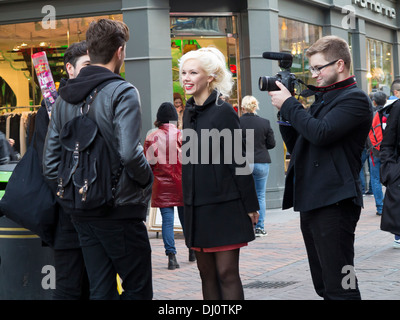 Junge Frau gefilmt von einem jungen Mann mit einer DSLR, Interviews mit Menschen auf der Carnaby Street, London Stockfoto