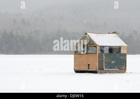 Ein Schneesturm wirbelt herum ein Eis Angeln Shack auf dem Eagle Lake, im Acadia National Park, Maine. Stockfoto