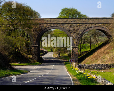 Ehemalige Eisenbahnbrücke nun auf dem Tissington Trail über eine leere Straße in der Nähe von Hartington Peak District Nationalpark Derbyshire UK Stockfoto