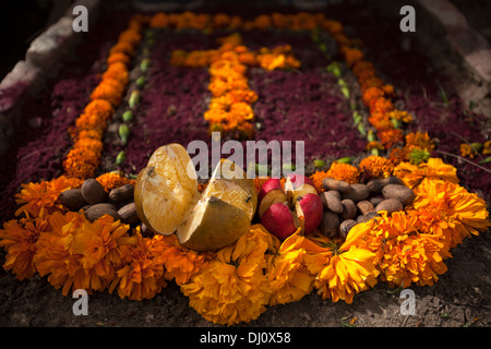 Ein Kreuz aus mit Ringelblumen schmückt eine Grab im Laufe des Tages der Toten in Teotitlan del Valle Friedhof in Oaxaca, Mexiko Stockfoto