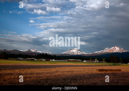 OREGON - Farm an die Stadt Schwestern mit den drei Schwestern und Broken Top Berge im Hintergrund. Stockfoto