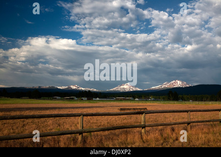 OREGON - Farm an die Stadt Schwestern mit den drei Schwestern und Broken Top Berge im Hintergrund. Stockfoto