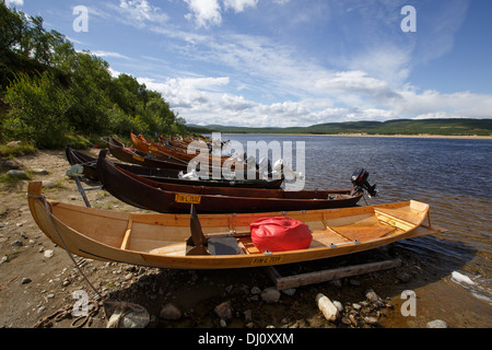 Holzboote mit Außenbordmotoren zum Lachsangeln am Fluss Teno, die natürliche Grenze zwischen Norwegen und Finnland in Lappland. Stockfoto