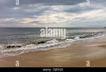 Sonnenuntergang Thottada Strand entlang und über das Arabische Meer als die Flut tritt in der Nähe von Kannur, Kerala, Indien. Stockfoto