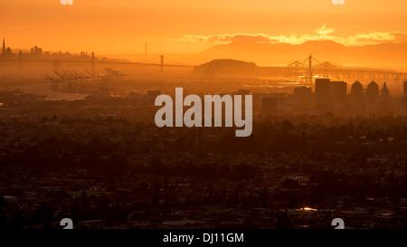 Blick vom Downtown Oakland, Kalifornien San Francisco Bay Bridge und der Golden Gate Bridge bei Sonnenuntergang Stockfoto