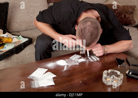 Kokain Drogendealer eine Linie. auf dem Sofa ist ein Geld-Koffer Stockfoto