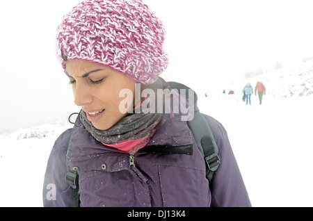 Junge Frau Gesichter Blizzard beim Wandern im verschneiten Tag im Peñalara, höchsten Berggipfel in der Bergkette der Sierra de Guadarrama Stockfoto