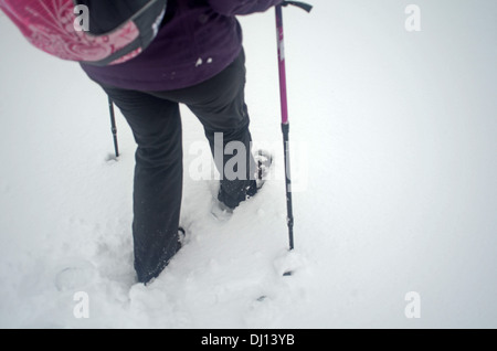 Junge Frau Wandern im verschneiten Tag im Peñalara, höchsten Berggipfel in der Bergkette der Sierra de Guadarrama, Spanien Stockfoto