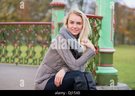 Schöne, glückliche junge Frau mit blonden Haaren entspannend in einem park Stockfoto