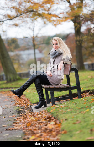 Schöne, glückliche junge Frau mit blonden Haaren entspannend in einem park Stockfoto