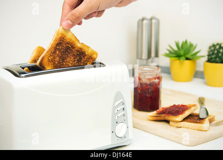 Das Frühstück zuzubereiten. Toaster und Toast mit Marmelade in modernen Küche Stockfoto